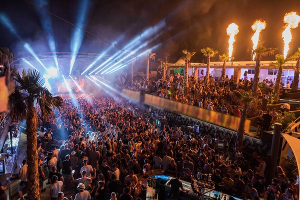 Fire jets, palm trees and lasers over a huge night crowd