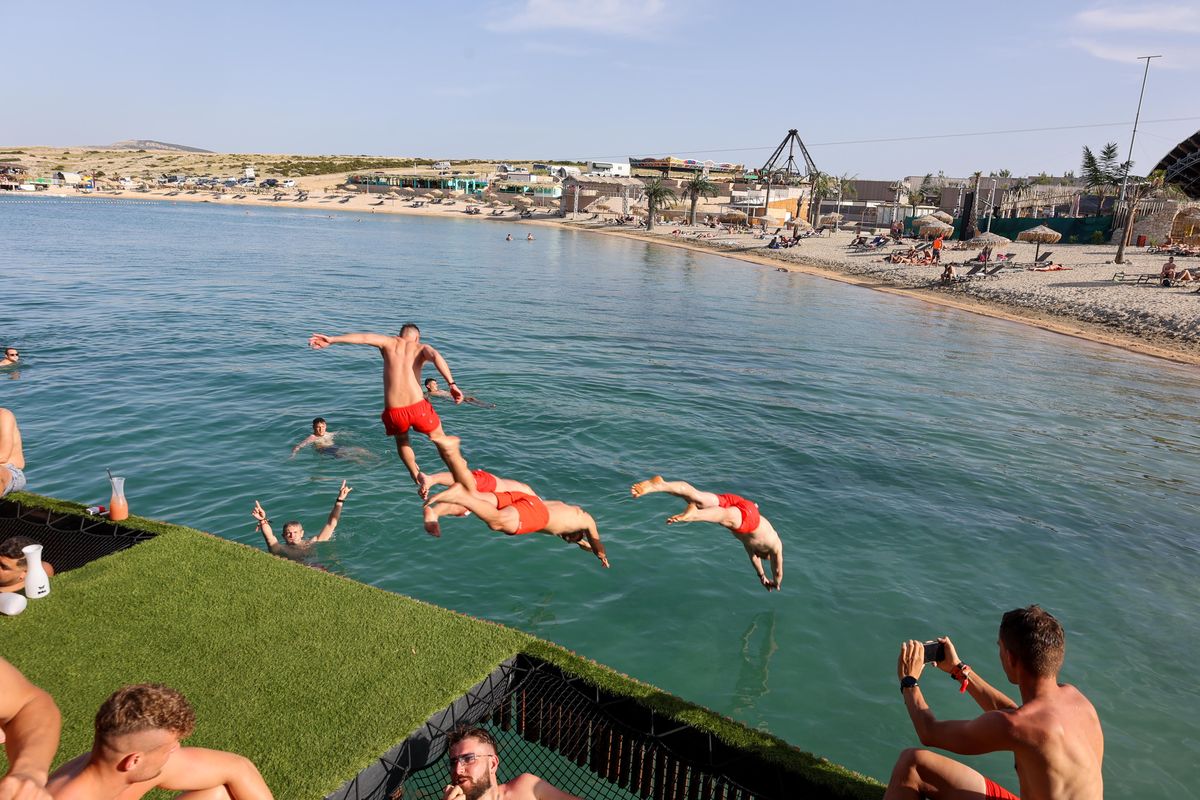 Friends jumping off the deck into the sea at Zrće Beach