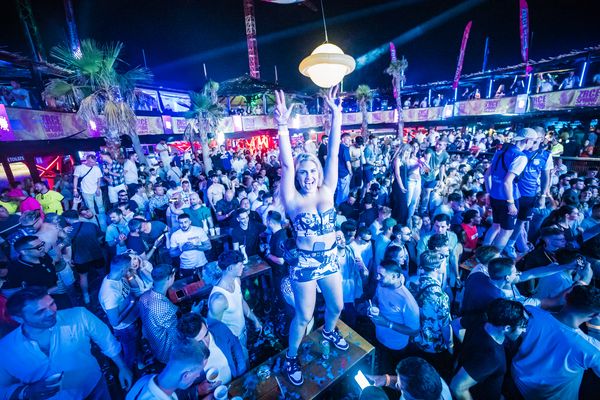 Girl standing above the crowd under blue lights