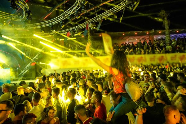 Girl on shoulders under yellow lights at a night party
