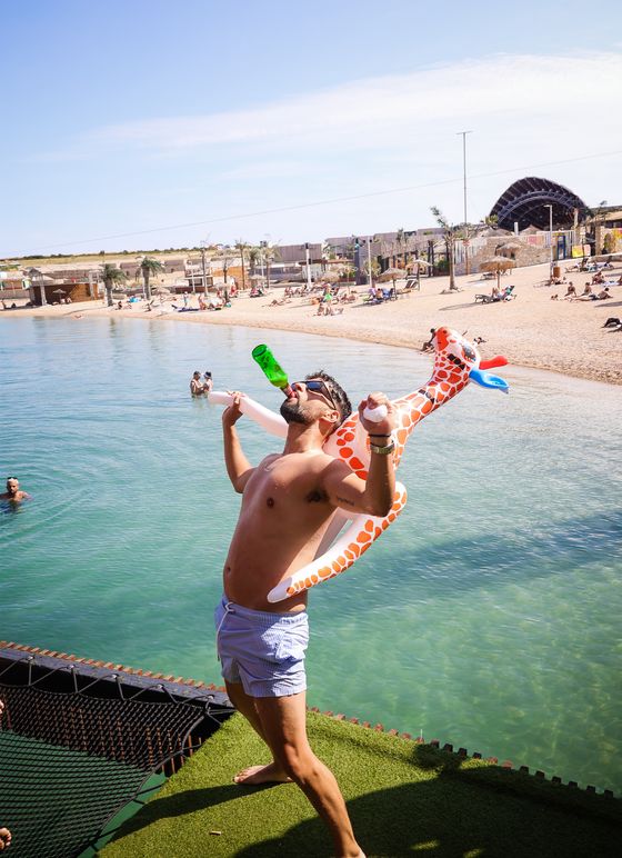 Guy celebrating on the pier above the sea