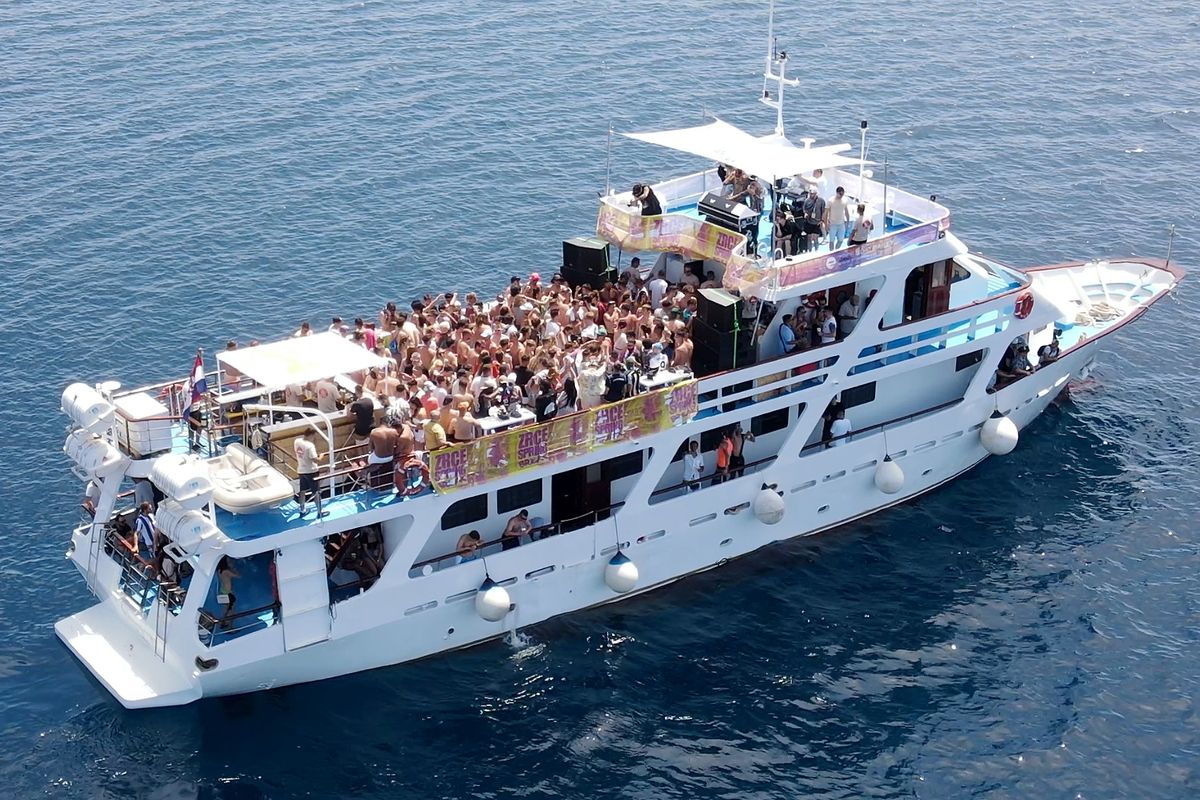 Party boat full of people on the open sea, seen from above