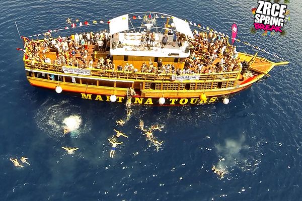 Party boat from above with guests swimming in the sea