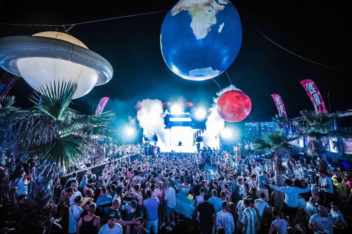 Planet balloons floating over a packed night crowd