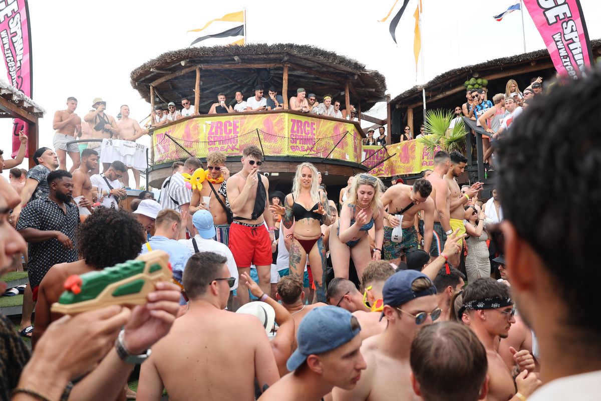 Pool party crowd with water guns in the sunshine