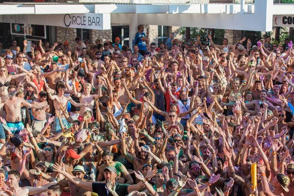 Sea of hands at a daytime pool party