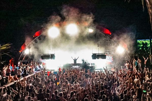 Stage blasting white light over the night crowd